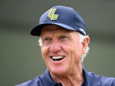 Greg Norman Breaks His Silence On LIV Golf’s Future Older man smiling, wearing a blue cap with a neon-green emblem on the front.