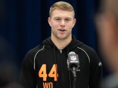Awesome Moment College Star Is Drafted While Playing Golf Athlete in a black hoodie with orange '44' speaks at a press conference, microphone with NFL logo in front of him.