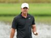 Koepka Drops Brutal Truth About LIV Golf’s Real Weakness Man in a black polo shirt and white Nike cap holding a golf ball on a golf course field.