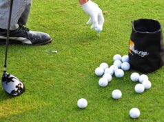 How To Go From Struggling to Break 90 to Shooting in the 70s Golfer placing a golf ball on the grass with a gloved hand, many balls scattered nearby and a bag nearby.