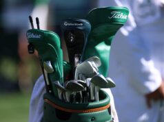 GolfWRX Reveals Why Dads Should Unload Golf Gear for Power Tools Close-up of a golf bag with multiple clubs, showing Titleist and TaylorMade branding outside on a sunny day.